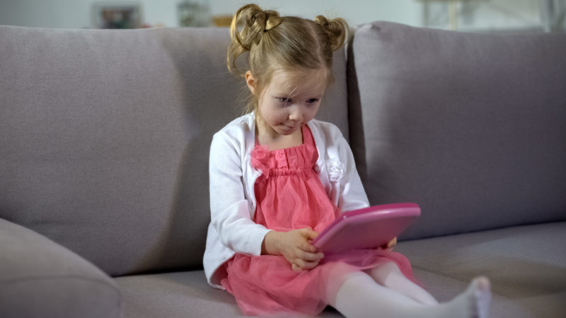 Little girl playing with a learning app.