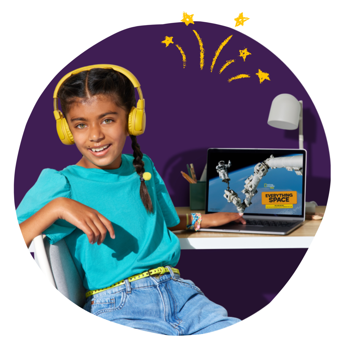 Girl sitting at a classroom desk reading on Epic on a computer.