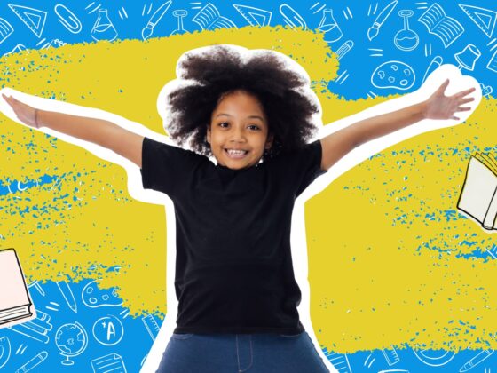 Smiling child with arms outstretched in front of a blue background covered in school supply doodles